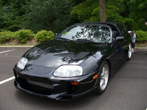 1991 Ford Probe - Front 3/4 view of a black Toyota Supra, likely a Mk4 generation.