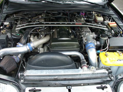 1991 Ford Probe - The engine bay features a custom intake system and an upgraded radiator, suggesting performance modifications.