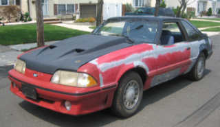 2001 Mercury Grand Marquis - This Ford Mustang appears to be undergoing bodywork, with primer and red paint visible.