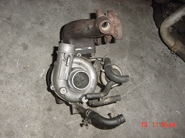 Turbocharger with aluminum housing and rusty flange on concrete floor