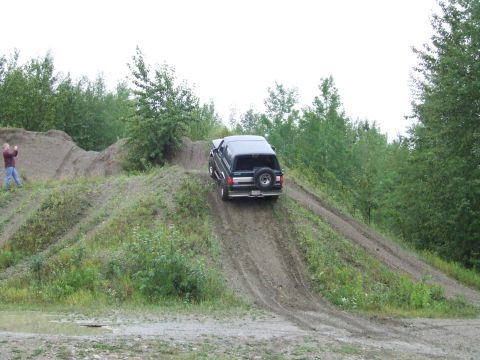 1990 Ford Bronco - 1990 Ford Bronco navigates an off-road course with steep inclines.