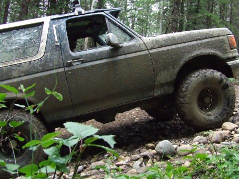 1990 Ford Bronco - This 1990 Ford Bronco navigates a challenging off-road course covered in mud.