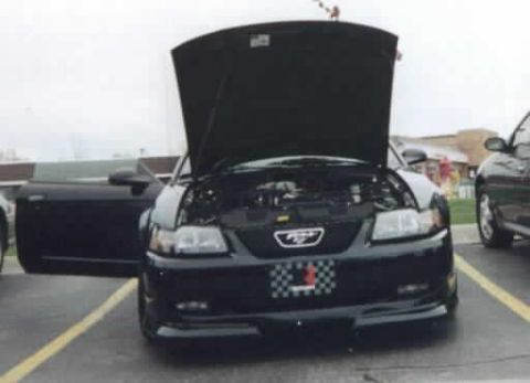 2001 Ford Mustang - Front view of a black 2001 Ford Mustang with its hood open, parked next to another vehicle.