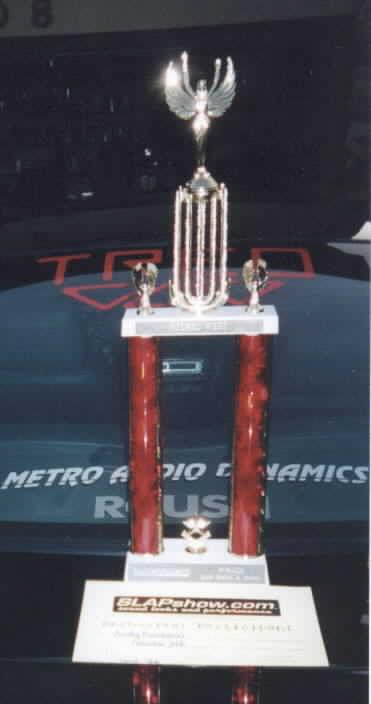 2001 Ford Mustang - Trophy displayed on the hood of a car, possibly at a car show event.