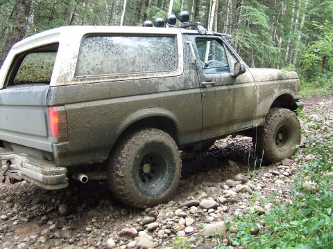 1990 Ford Bronco - This 1990 Ford Bronco is covered in mud after driving on a rough, rocky trail through the woods.