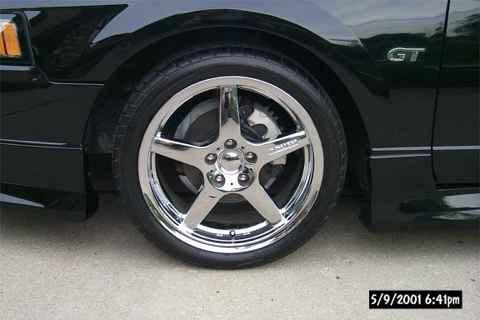 2001 Ford Mustang - A close-up shot of the front wheel and fender of a black 2001 Ford Mustang GT.