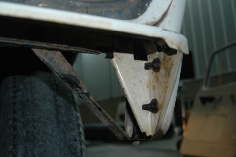 1963 Ford F-250 - Detail of a truck's undercarriage, showing a bracket and tire. Another vehicle is visible in the background.