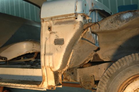 1963 Ford F-250 - Close-up of a heavily rusted truck chassis, revealing structural components and a tire.