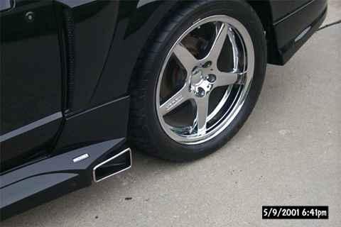 2001 Ford Mustang - Close-up of a 2001 Ford Mustang's side skirt and chrome wheel.