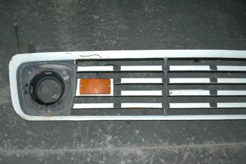 1963 Ford F-250 - This is a close-up view of a truck's front grille, an amber turn signal and a headlight mounting point.
