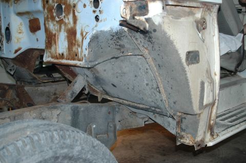 1963 Ford F-250 - Detail of the frame and wheel well area of a 1963 Ford F-250, showing signs of rust and wear.