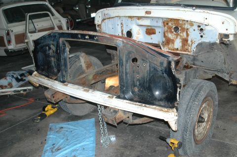 1963 Ford F-250 - The front end of a disassembled 1961 Ford F-100 truck is visible, with another vehicle in the background.