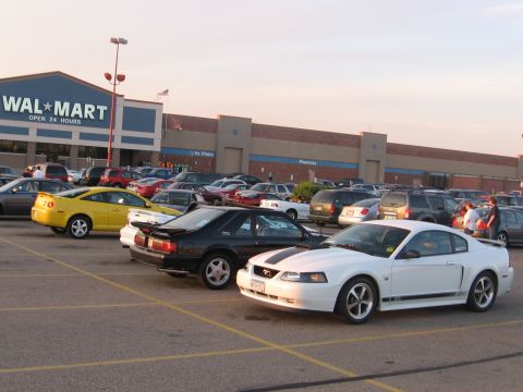 1989 Ford Mustang - A Walmart parking lot scene with multiple vehicles under a bright sky.