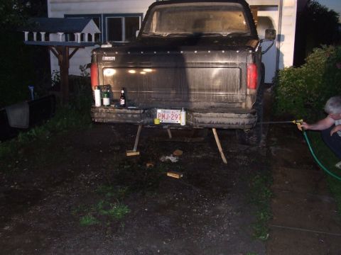 1990 Ford Bronco - Rear view of a black pickup truck, possibly a Ford Bronco, with its license plate visible and supported by wooden blocks.