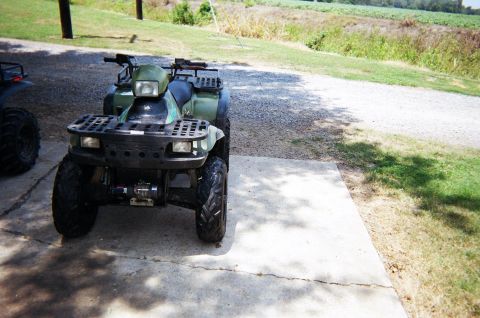 1995 Ford Bronco - Two ATVs are parked outside on a sunny day with fields in the background.