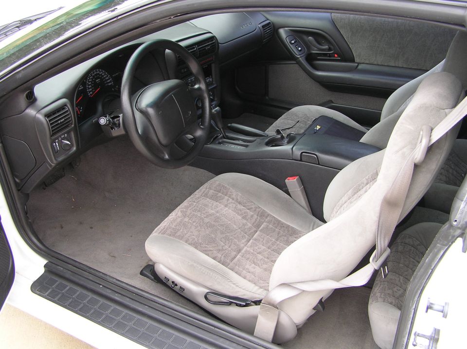 Interior of a 2001 Chevrolet Camaro showing gray cloth seats, dashboard, steering wheel, and center console