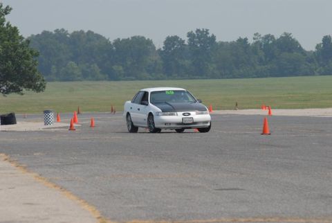 1992 Ford Taurus - A 1992 Ford Taurus navigates a course marked by orange cones on a sunny day.
