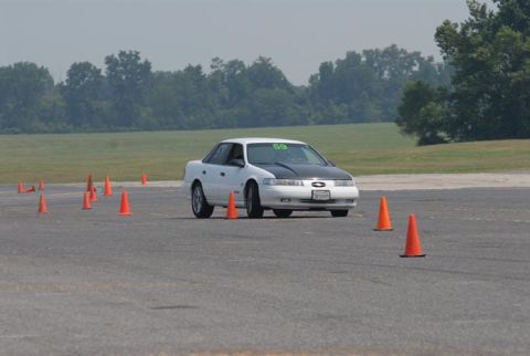 1992 Ford Taurus - A 1992 Ford Taurus participates in a driving event on a paved course marked with traffic cones.