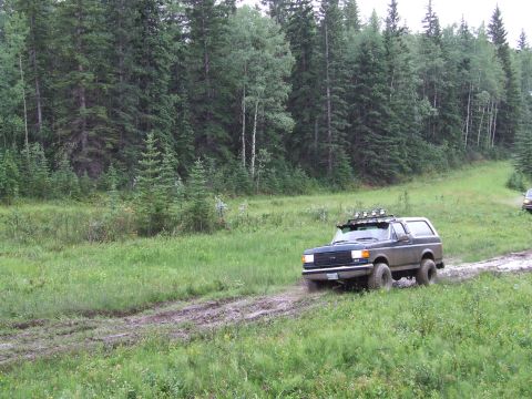 1988 Ford Bronco - This 1987 Ford Bronco navigates a muddy path through a wooded area.