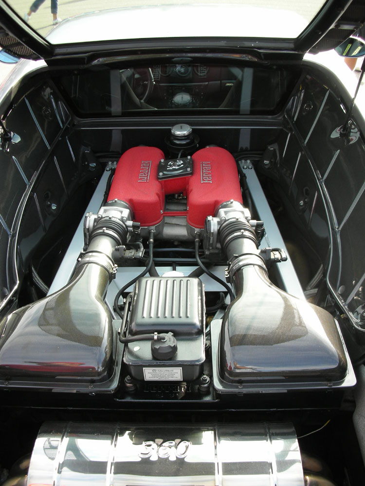 Mid-engine bay of a Ferrari 360 with red crackle cam covers under glass