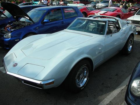 1998 Ford Crown Victoria - light blue C3 Corvette Stingray T-top coupe parked among other cars at an outdoor show.