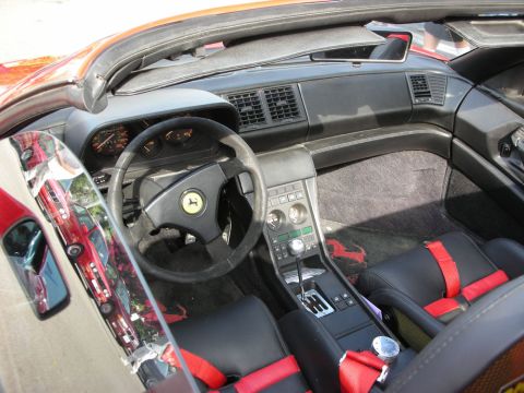 1998 Ford Crown Victoria - Interior of a Ferrari with black dash, red leather seats and a steering wheel bearing the yellow prancing-horse emblem.