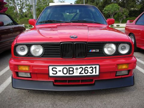 1998 Ford Crown Victoria - Head-on view of a red BMW E30 M3 with the M3 kidney-grille badge and German plate S-OB 2631.
