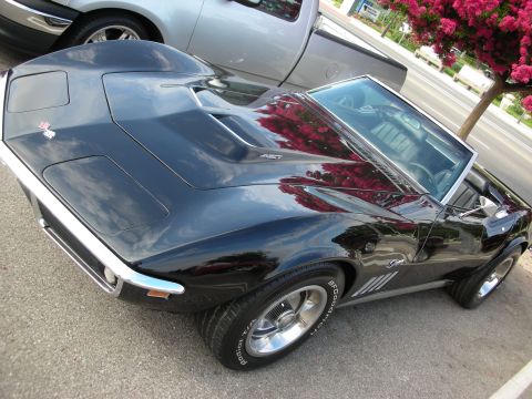 1998 Ford Crown Victoria - black C3 Corvette Stingray convertible parked at an angle with chrome bumpers and styled wheels.