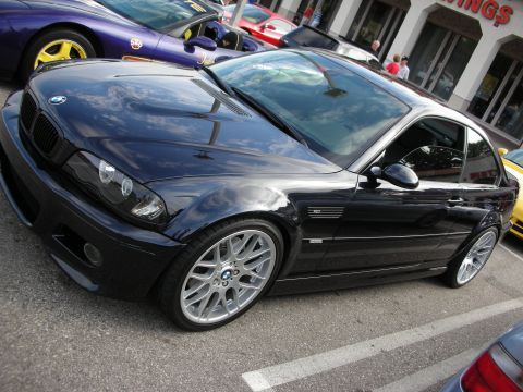 1998 Ford Crown Victoria - black BMW E46 M3 coupe parked at a car show, shown from the front three-quarter on silver alloy wheels.