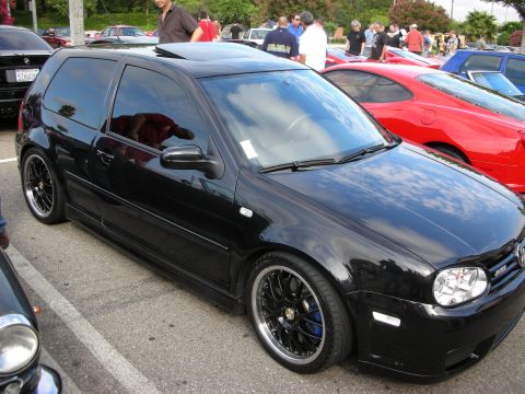 1998 Ford Crown Victoria - lowered black Volkswagen Golf hatchback with a sunroof and black multi-spoke wheels parked among red and other cars at a car meet.