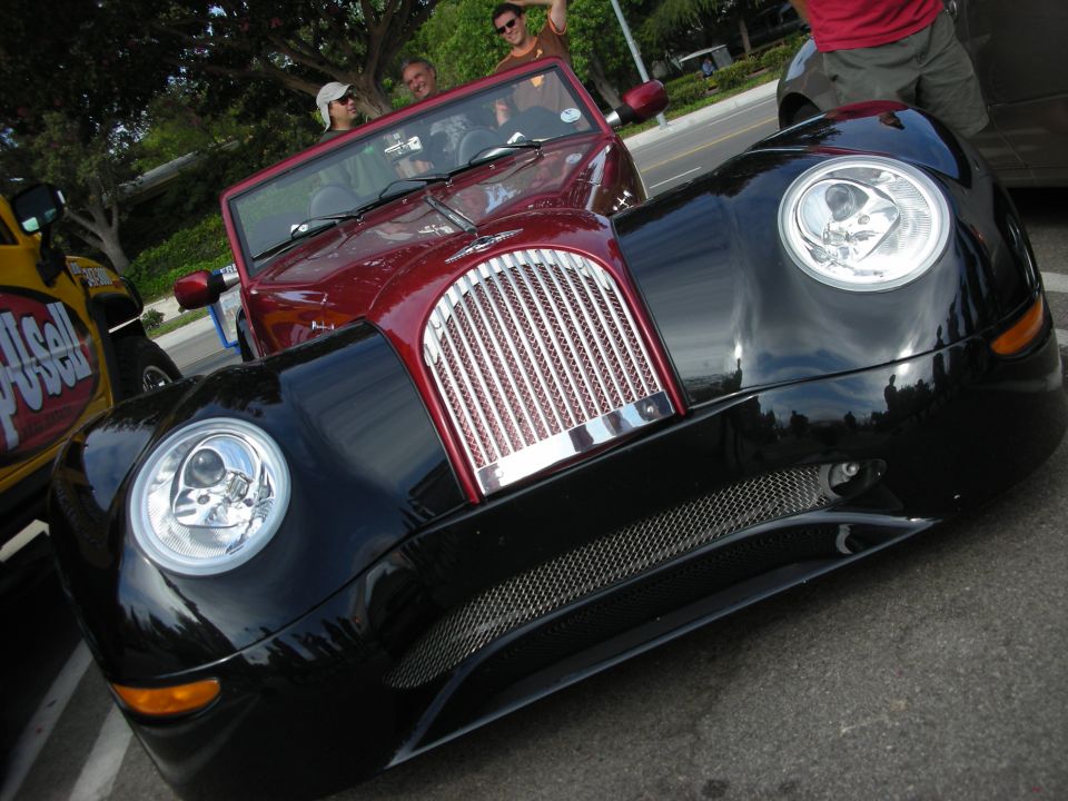 Front of a black and red custom roadster with skull-design headlight inserts