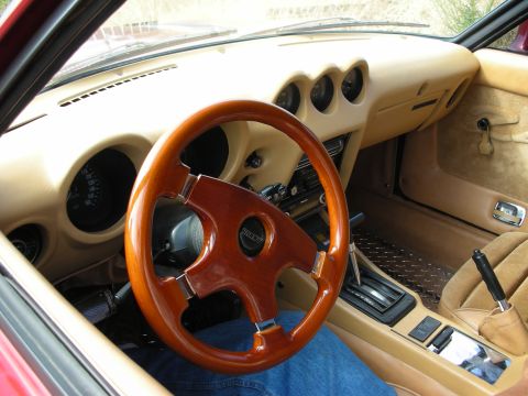 1998 Ford Crown Victoria - Tan leather interior of a classic Japanese sports car with a wood-rimmed steering wheel, three center gauges and a manual shifter.