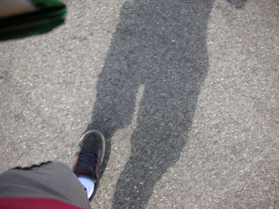 Photographer's shoe and shadow on parking-lot asphalt
