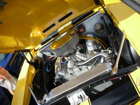 1998 Ford Crown Victoria - engine bay of a yellow car showing a chromed round air cleaner atop a polished V8 with braided lines.
