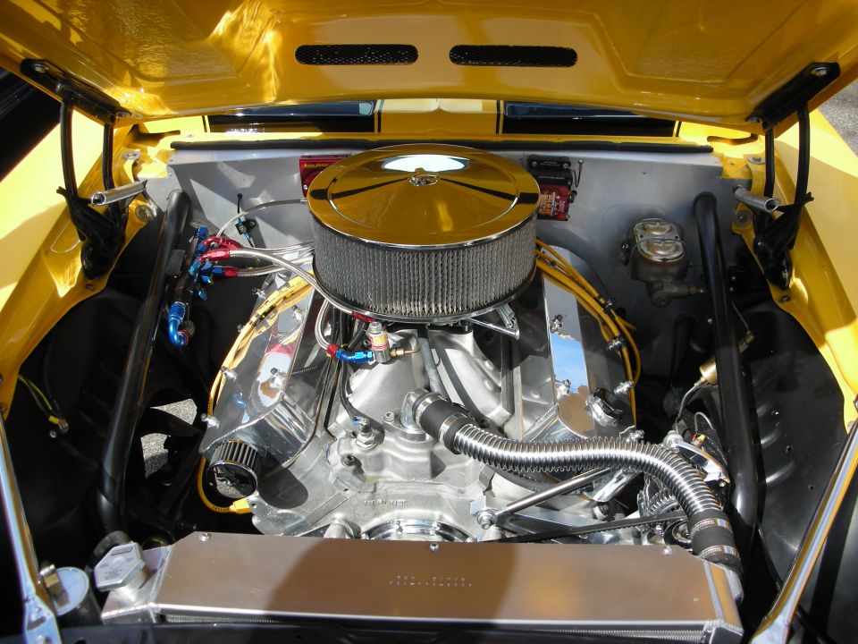 Polished V8 engine with chrome air cleaner in a yellow hot rod