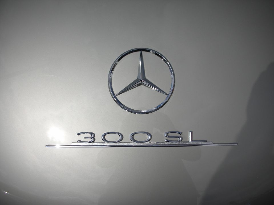 Close-up of Mercedes star emblem and 300SL chrome script on body