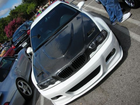1998 Ford Crown Victoria - Overhead front view of a white BMW with a bare carbon-fiber hood, twin kidney grilles and angel-eye headlights.