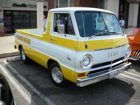 1998 Ford Crown Victoria - yellow-and-white Dodge A100 cabover pickup with chrome wheels parked at a street show, DODGE lettering on the nose.