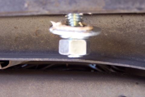 1990 Ford Bronco - Close-up of a single tie-down bolt attached to a vehicle's frame.