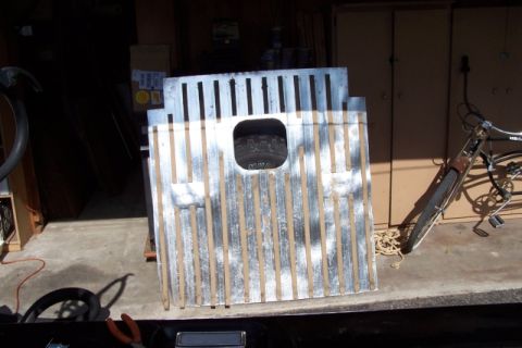 1990 Ford Bronco - Two metal tie-down panels are stacked, with a tire visible through a square cutout in the upper panel.