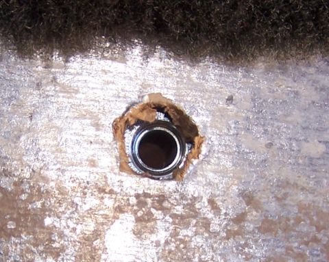1990 Ford Bronco - A close-up view of a tie-down anchor point, showing its metal construction and surrounding material.