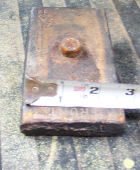 1978 Ford Bronco - Close-up of a rusty metal part being measured with a tape measure.