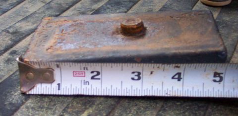 1978 Ford Bronco - A close-up view of a rusty leaf spring plate being measured with a tape measure.