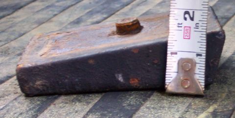 1978 Ford Bronco - A close-up view of a rusty metal part with a bolt, measured by a tape measure.