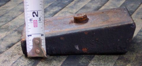 1978 Ford Bronco - A rusty metal block with a bolt on top is measured with a tape measure, showing approximately 1.5 inches in height.