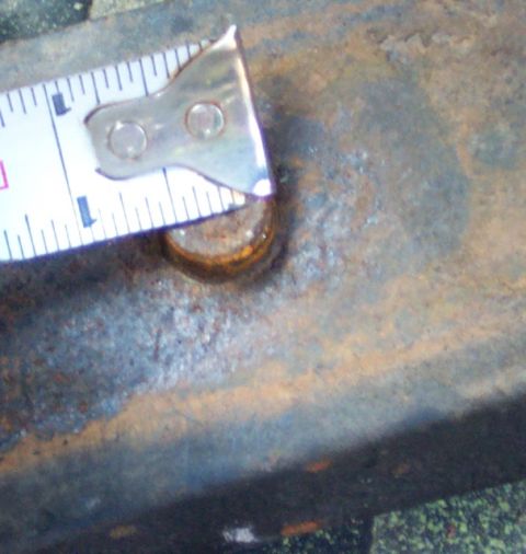 1978 Ford Bronco - Close-up of a rusty bolt head being measured with a tape measure.