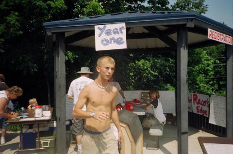 1995 Ford Probe - An outdoor event registration booth is set up with people signing in and signs indicating 'Year One' and 'Registration'.