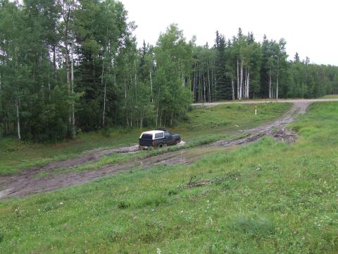 1988 Ford Bronco - Ford Bronco navigates a muddy trail in a wooded area.