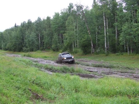 1988 Ford Bronco - Ford Bronco navigating a muddy trail during an off-road excursion.