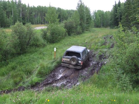 1988 Ford Bronco - Ford Bronco struggling through deep mud on an overgrown trail.